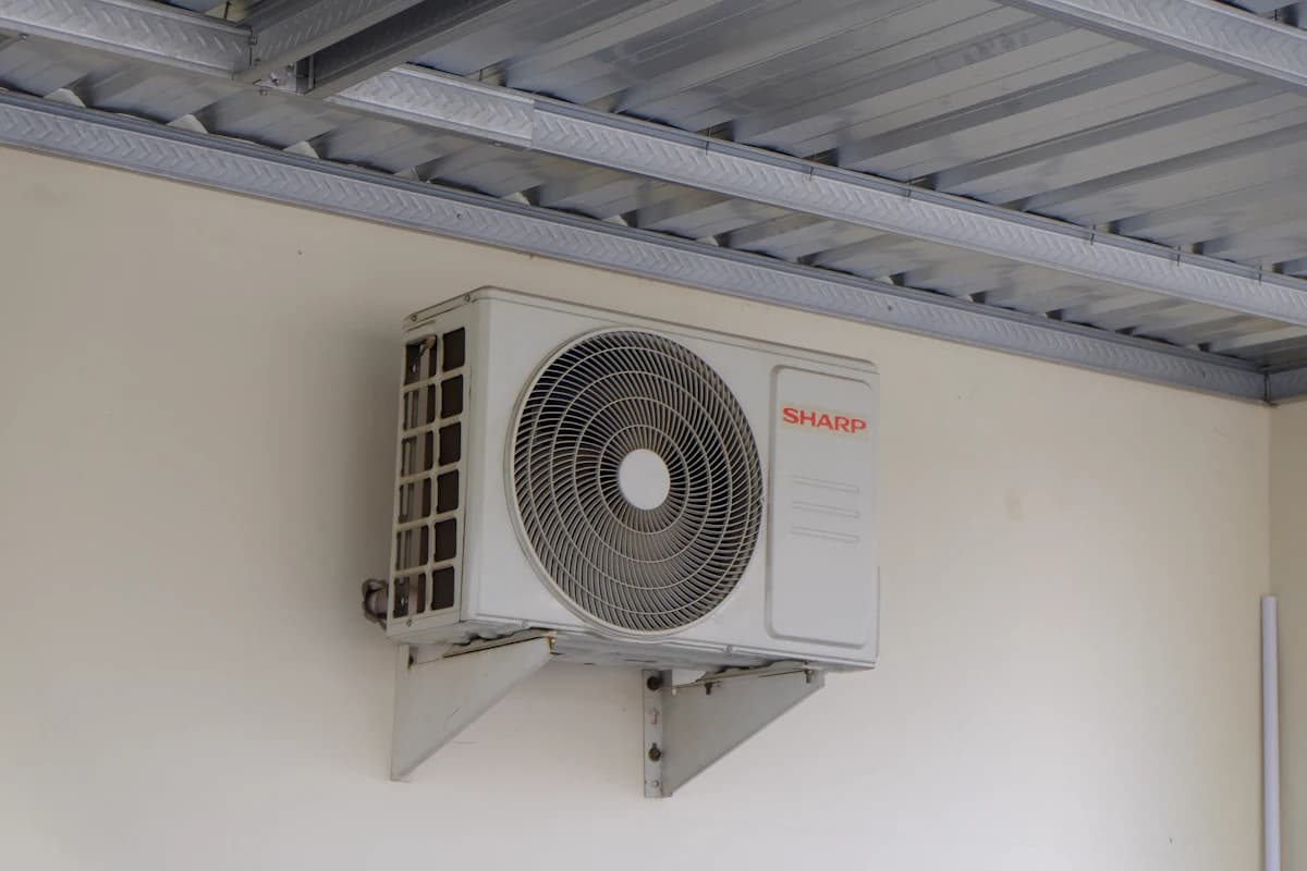 Airco buitenunit aan een witte gevel, geluidsoverlast voor de buren begint vaak bij verkeerde plaatsing
