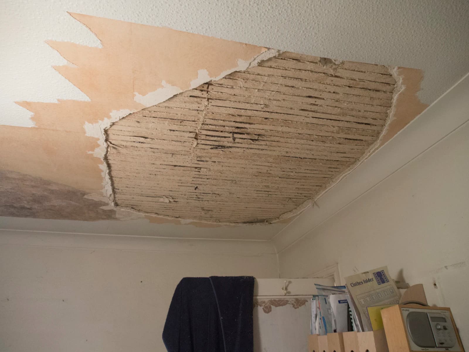 Bruine vochtplek op een wit plafond door een daklekkage