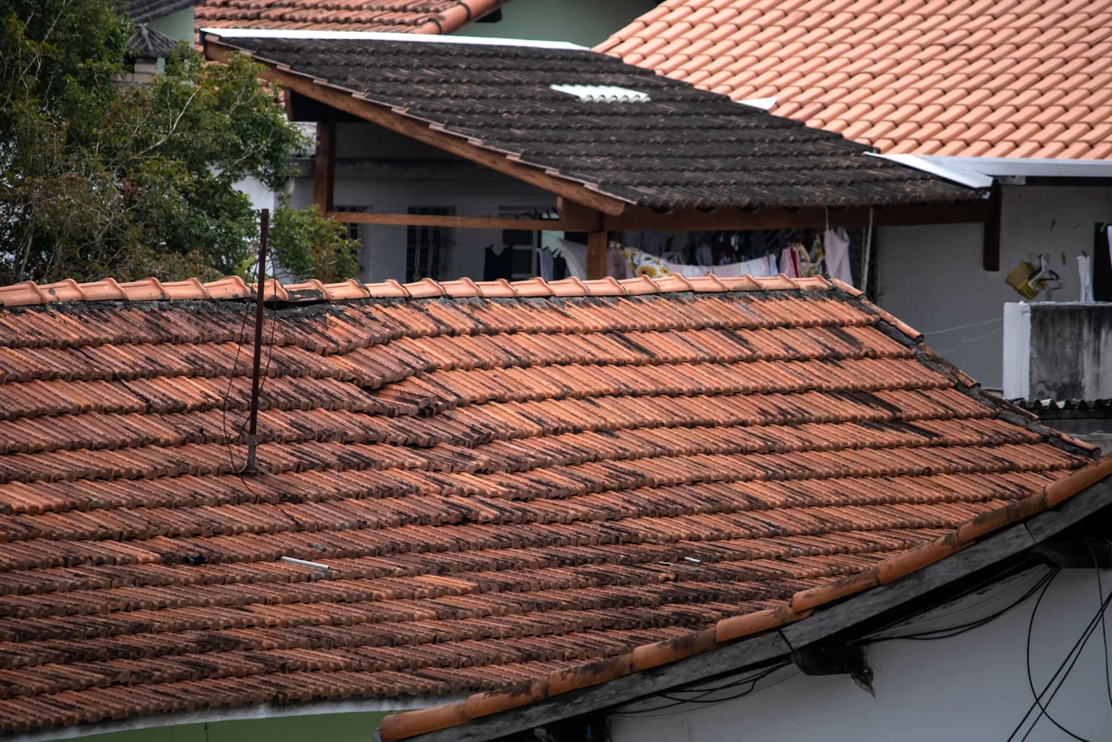 Beschadigd dak van een woning na een zware storm met losgewaaide dakpannen