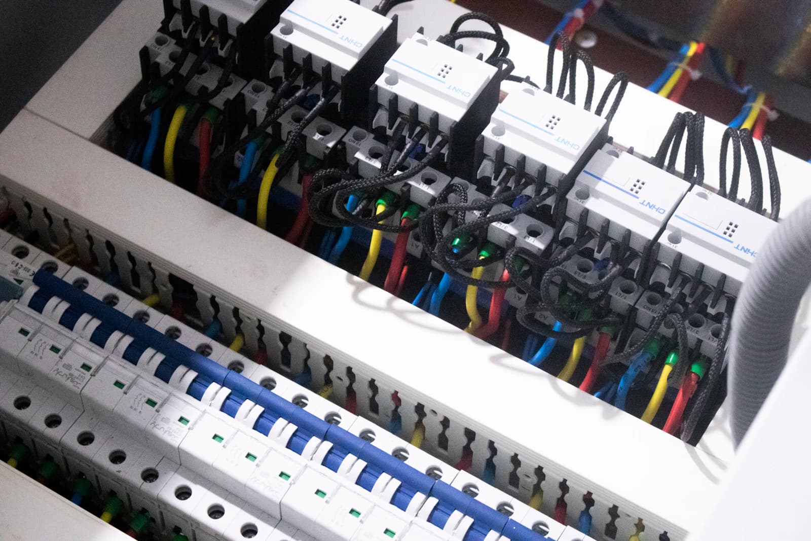 Elektricien controleert een groepenkast met multimeter tijdens een NEN 1010 keuring van de elektrische installatie