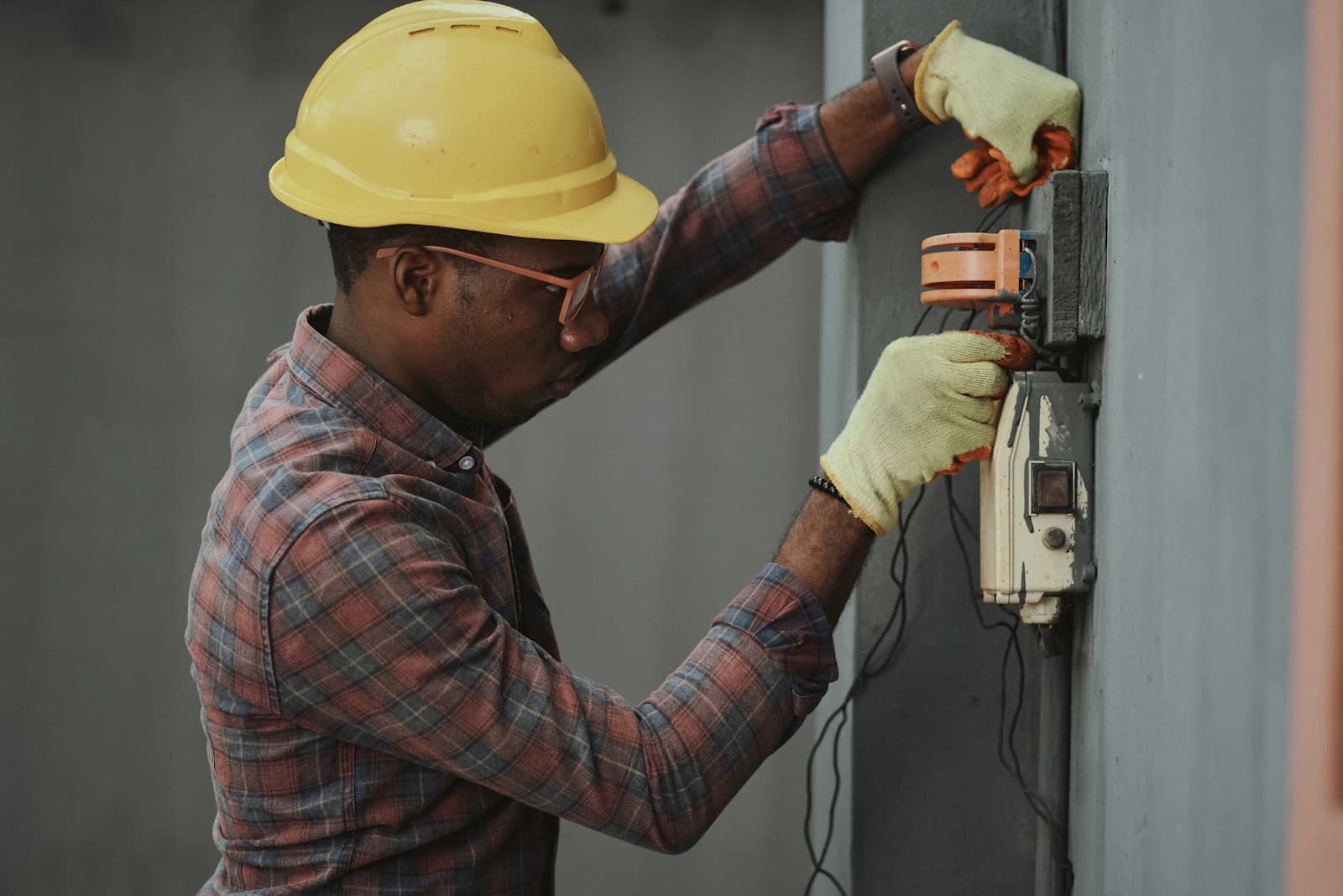 Elektricien werkt aan een meterkast met groepenkast en zekeringen tijdens een installatie