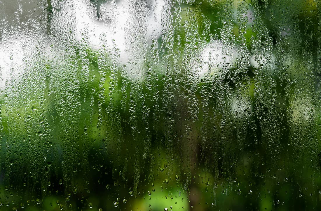 Beslagen raam met waterdruppels door condensvorming op dubbel glas