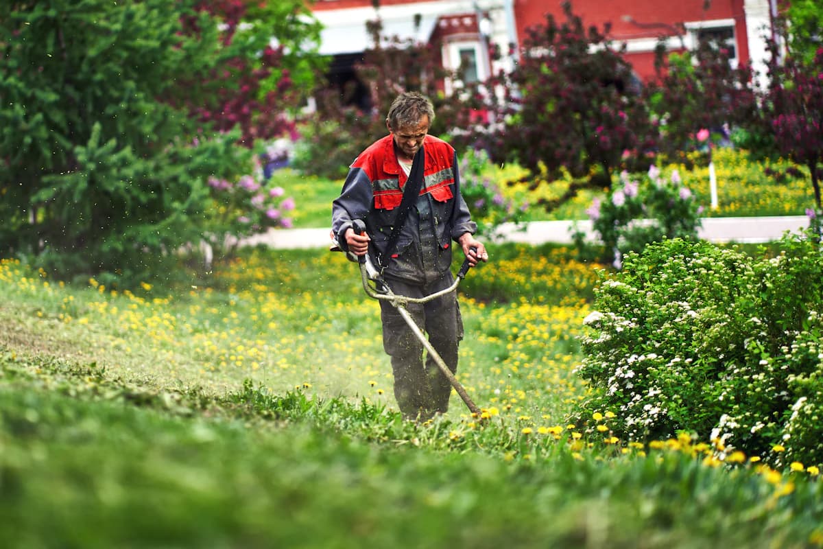 Hovenier in werkkleding met schop in een tuin tijdens aanlegwerkzaamheden