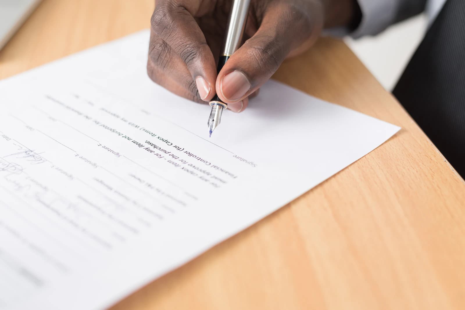Klant en vakman bekijken samen een schriftelijke offerte met pen, contract en rekenmachine op tafel