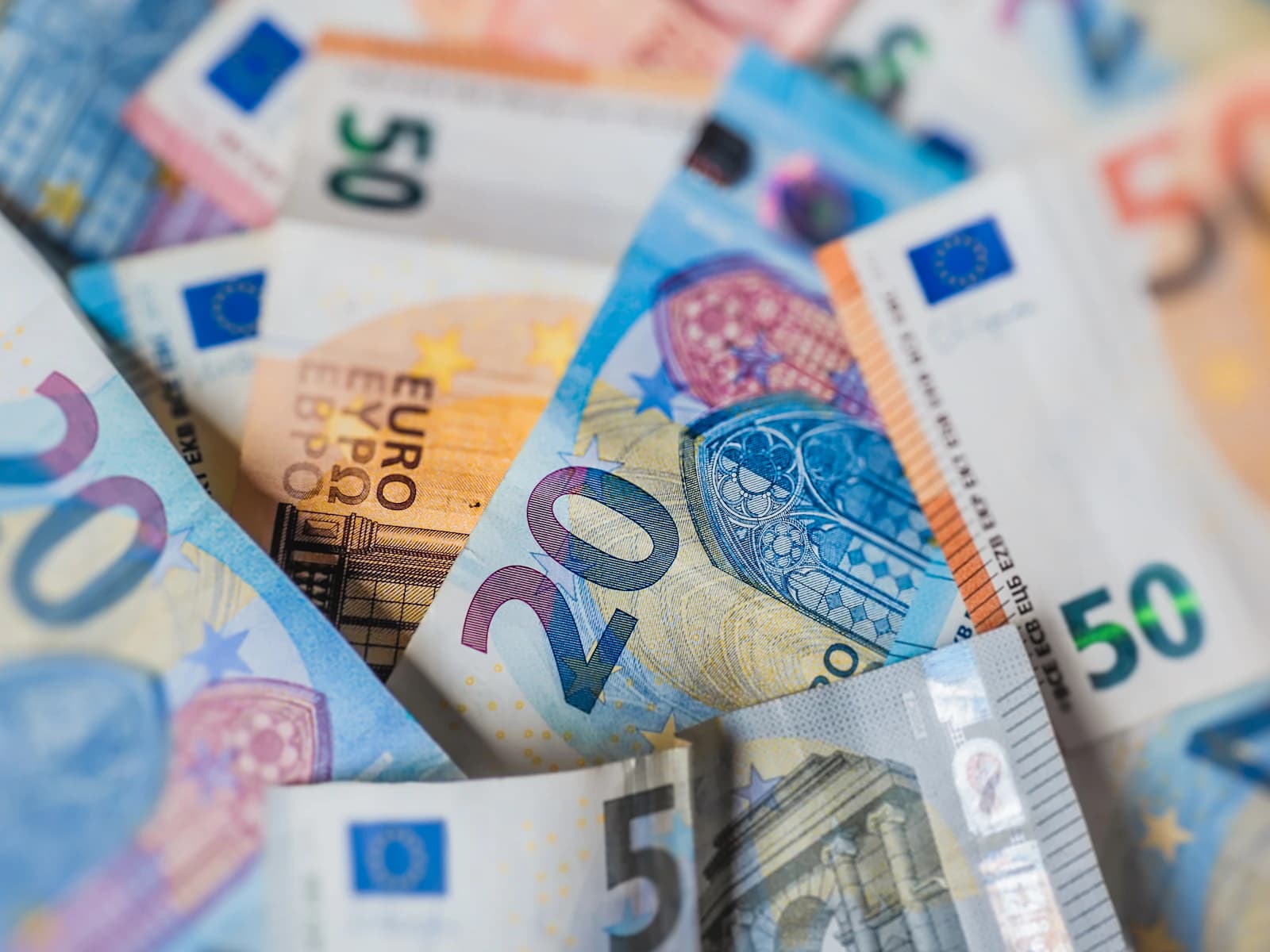 Stapel euro biljetten naast een factuurbonnetje, contant betalen of factuur vragen aan een vakman