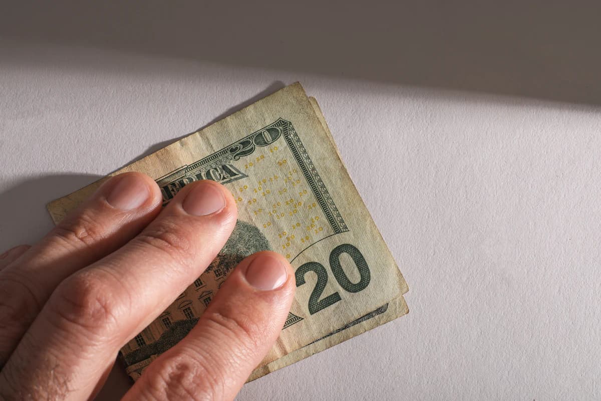 Hand die contant geld aanneemt, illustratie bij artikel over de risico's van zwart werk