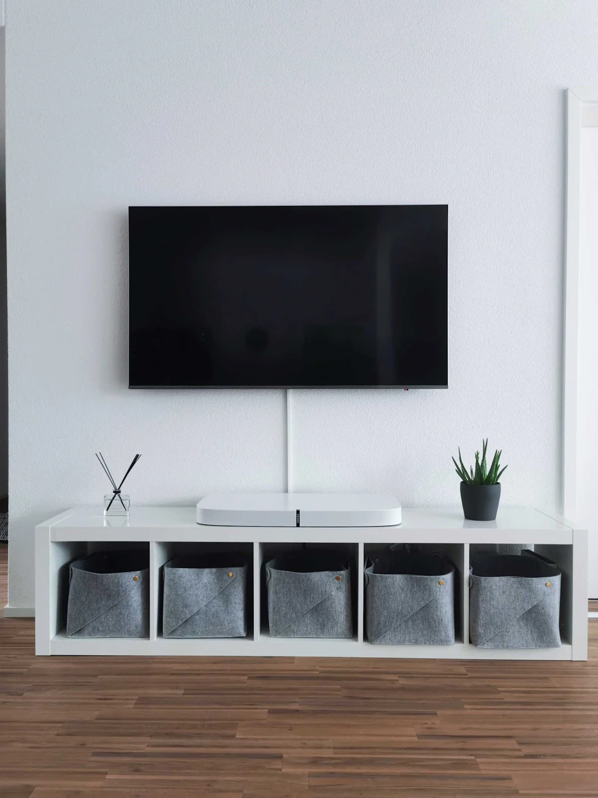 Vakman hangt een flatscreen-tv aan de muur met een wandbeugel en waterpas