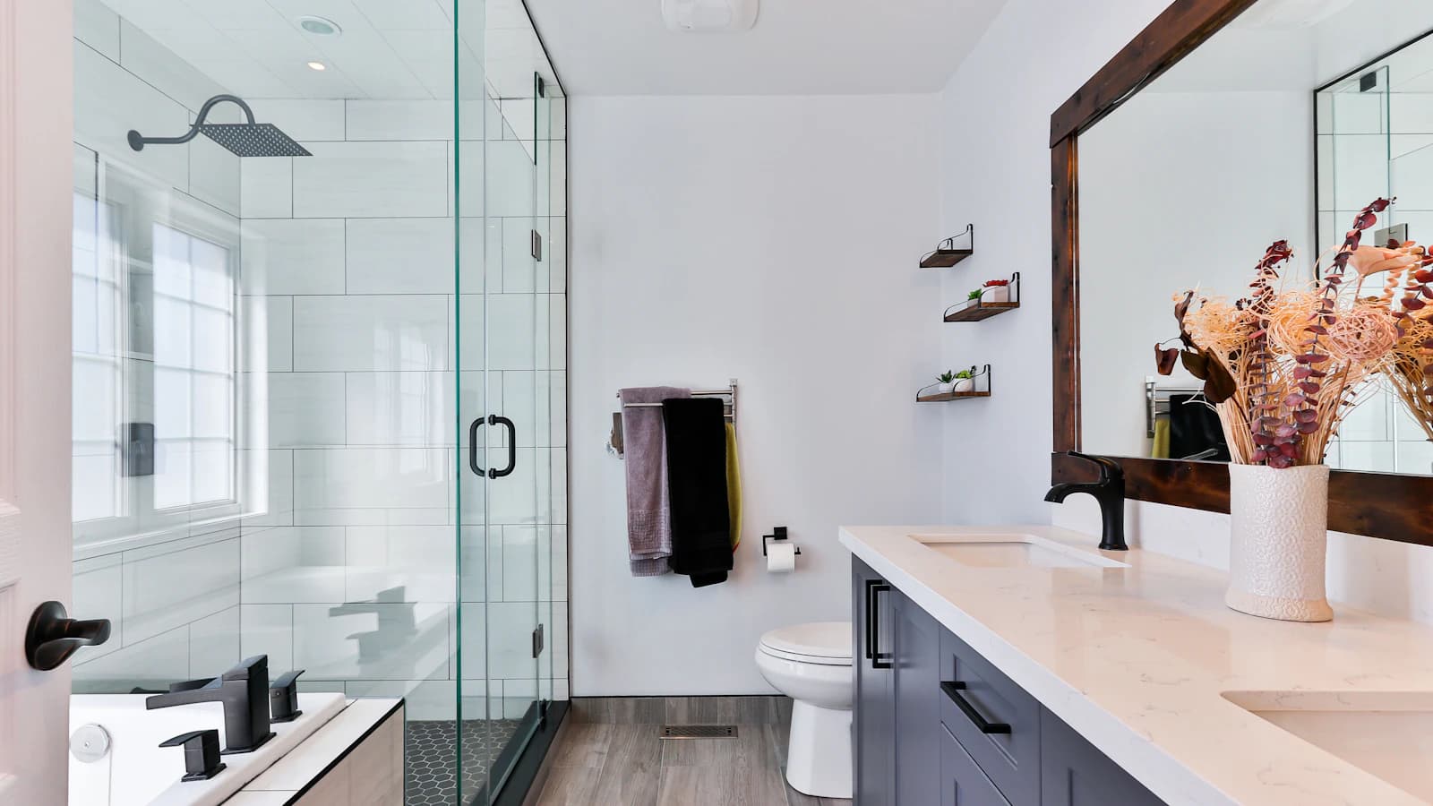 Loodgieter werkt aan waterleidingen in een gerenoveerde badkamer met blote leidingen