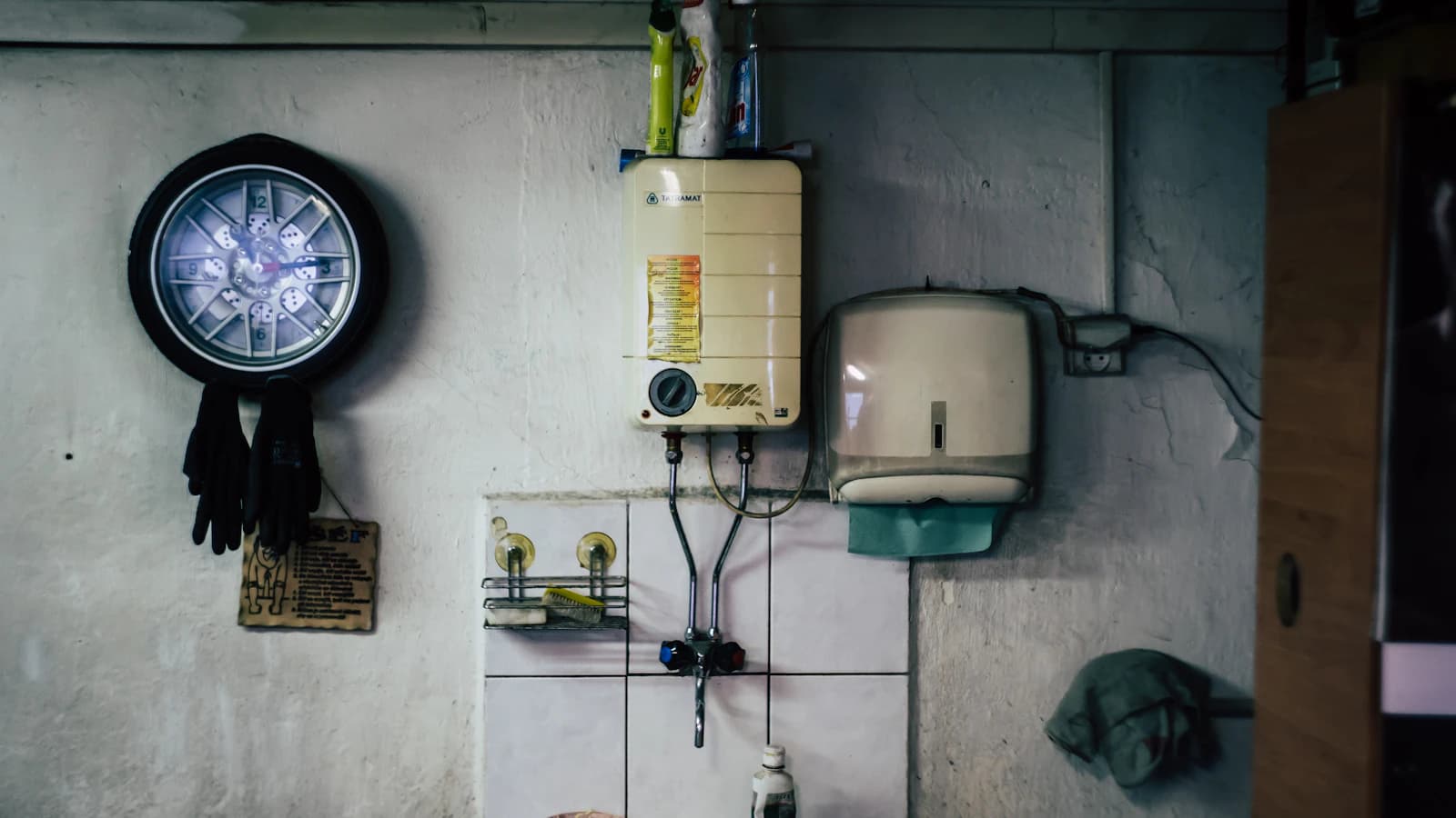 Witte cilindrische boiler aan de wand in een technische ruimte van een woning