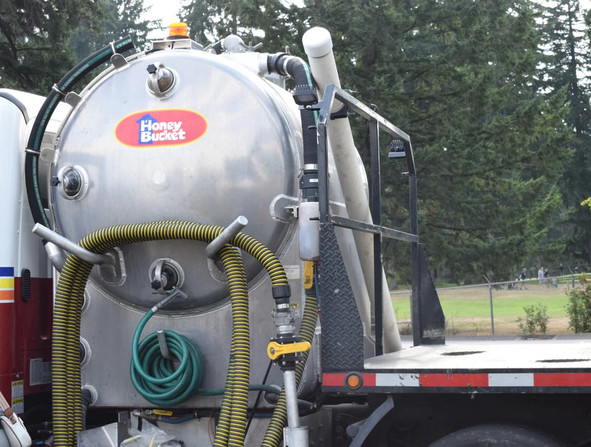 Vacuümwagen van een rioolservice die een septische put leegzuigt in een landelijk gebied