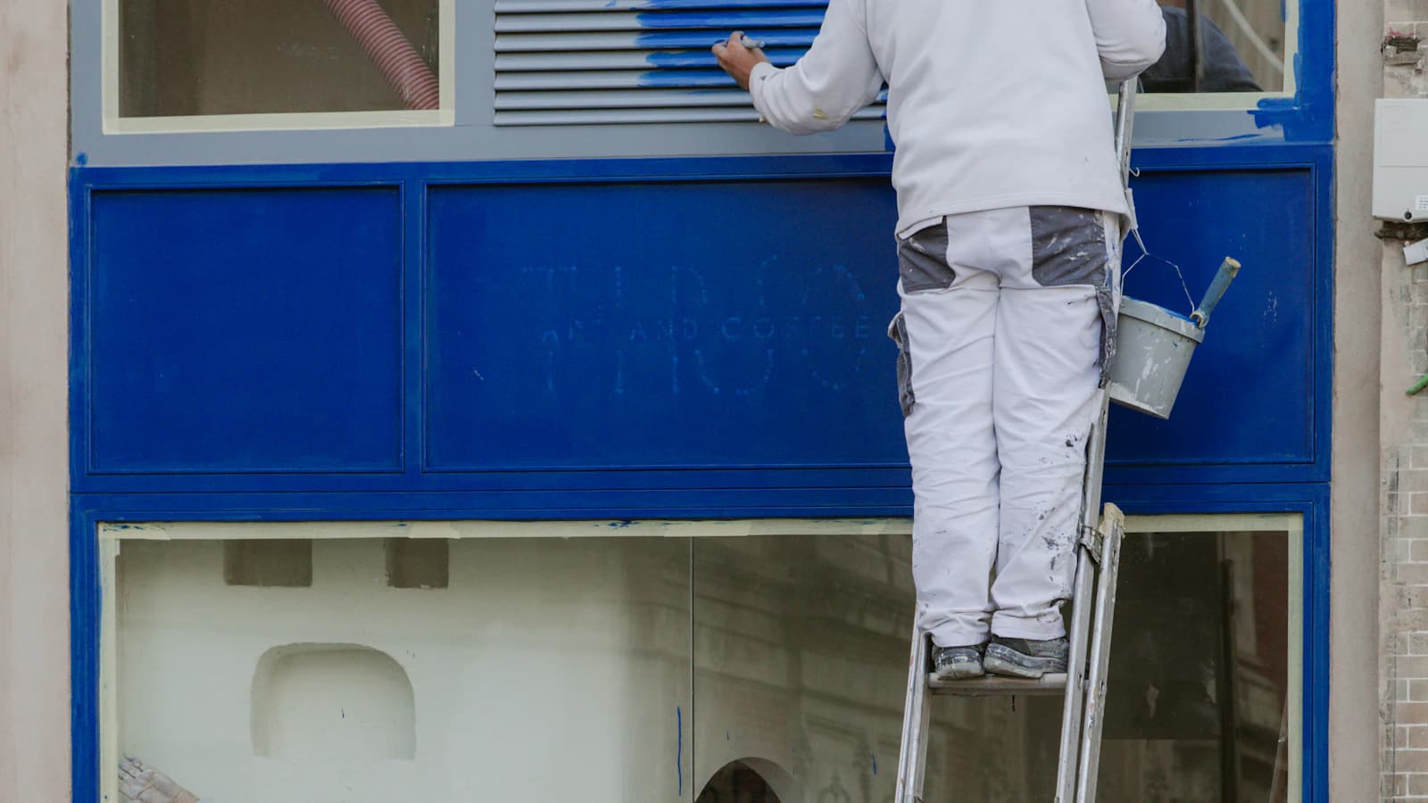 Schilder schildert een houten kozijn van een Nederlandse woning