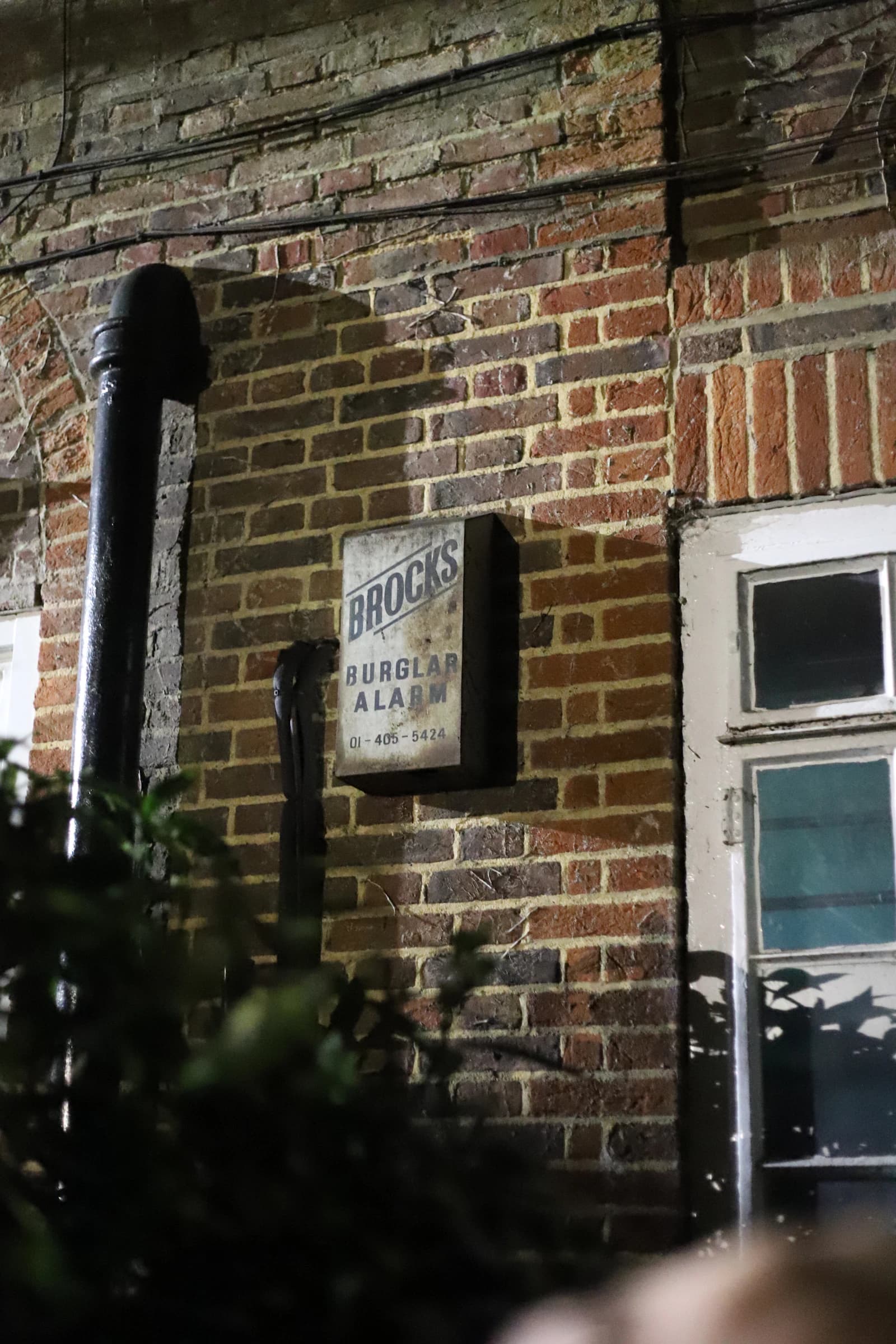 Een ouderwetse inbraakalarmkast aan een gevel, symbool voor woninginbraak en beveiliging