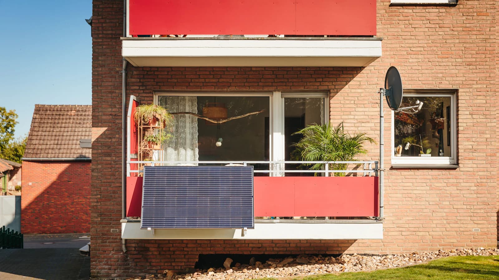Plug-and-play zonnepaneel hangend aan een balkon van een Nederlands appartement