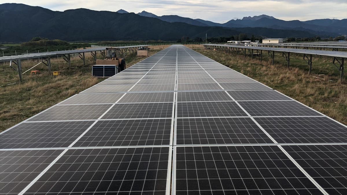 Iemand maakt zonnepanelen op een dak schoon met een zachte borstel en water